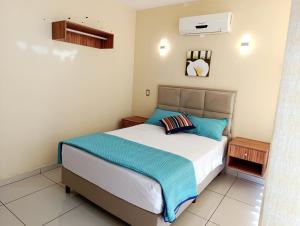 ein Schlafzimmer mit einem großen Bett mit blauen Kissen in der Unterkunft Centrico Espacio Cruceño Full in Santa Cruz de la Sierra + 7 Fotos