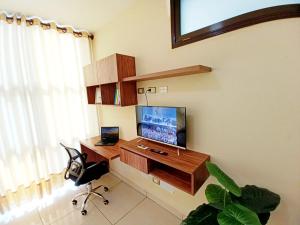 ein Zimmer mit Schreibtisch, Fernseher und Computer in der Unterkunft Centrico Espacio Cruceño Full in Santa Cruz de la Sierra