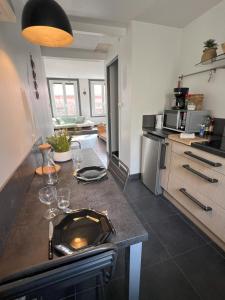 een keuken met een aanrecht met wijnglazen erop bij Gîte Petite Palette in Ribeauvillé +15 foto's