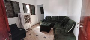 een woonkamer met een groene bank en een ventilator bij Casa para tecnoshow 2025 rioverde in Rio Verde