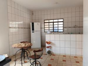 een keuken met een koelkast en een tafel en stoelen bij Casa para tecnoshow 2025 rioverde in Rio Verde