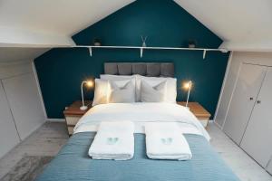 ein Schlafzimmer mit einem großen Bett mit blauen Wänden in der Unterkunft 4BR Town House, Self Check In, Parking, By DerBnB in Derby
