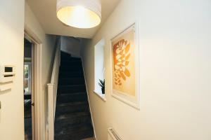 a hallway with a staircase with a painting on the wall at 3BR Town House, Self Check In, Parking, By DerBnB in Derby