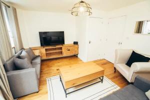 a living room with a couch and a television at 3BR Town House, Self Check In, Parking, By DerBnB in Derby +31 photos