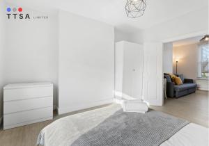 ein weißes Schlafzimmer mit einem Bett und einer Couch in der Unterkunft 1-Bedroom Apartment near East Croydon Station - 2 in South Norwood