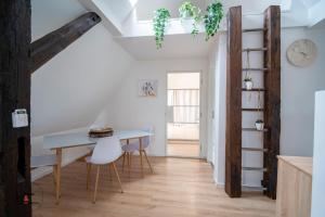 a kitchen and dining room with a table and chairs at Les Combles du Moulin in Geudertheim
