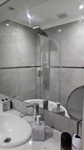 a bathroom with a sink and a glass shower at Departamento frente al mar con cochera in Mar del Plata