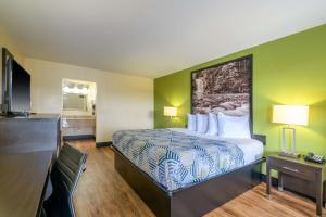 a hotel room with a bed and a flat screen tv at Motel 6 Forsyth, GA Tift College in Forsyth