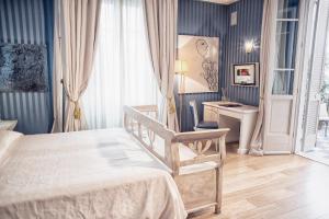 ピエトラサンタにあるHotel Palazzo Guiscardoのベッドルーム1室(ベッド1台、デスク付)
