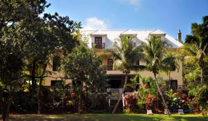 a building with palm trees in front of it at Mahogany Hall Luxury Boutique Resort in San Ignacio