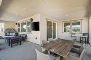 Una sala de estar con una mesa y sillas de madera. en Luxury Desert Escape Private Pool Putting Green Outdoor Oasis, en La Quinta