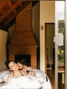 a man and a woman laying in a bed at Chalé Portal Lazer Propriedade Inteira in Gonçalves