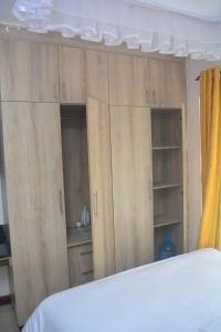 Schlafzimmer mit Holzschränken und einem Bett in der Unterkunft Simba Bnb Karen in Nairobi + 1 Foto