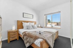 a bedroom with a bed with two shoes on it at City Haven Modern 2BR Apartment on Carrington St in Adelaide +21 photos