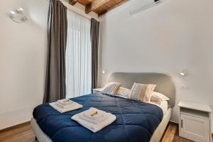 a bedroom with a blue bed with towels on it at Cinque Terre Memory Affittacamere in La Spezia