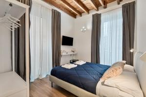 a bedroom with a blue bed in a room with windows at Cinque Terre Memory Affittacamere in La Spezia