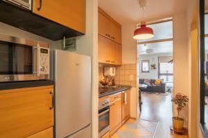 Una cocina con gabinetes de madera y refrigerador. en Explorer House Bremen, en Bremen