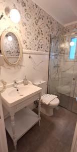a bathroom with a sink and a shower and a toilet at Garitsa Bay Apartment in Corfu Town