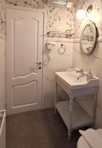 a white bathroom with a sink and a mirror at Garitsa Bay Apartment in Corfu Town +45 photos
