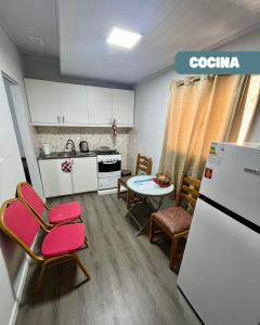 パイサンドゥーにあるApartamento para tres personas a cuadras del hospitalのキッチン(冷蔵庫、テーブル、椅子付)