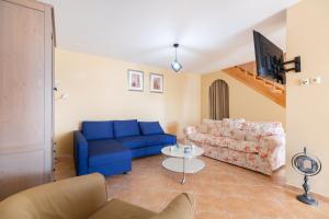 a living room with a blue couch and a table at Spacious Villa With a Pool in Nea Peramos