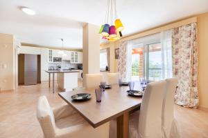 a dining room and living room with a table and chairs at Spacious Villa With a Pool in Nea Peramos