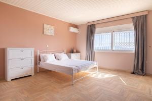 a bedroom with a white bed and a window at Spacious Villa With a Pool in Nea Peramos +45 photos