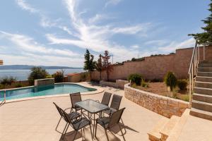 a patio with a table and chairs next to a swimming pool at Spacious Villa With a Pool in Nea Peramos