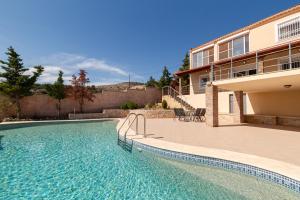 a swimming pool in front of a house at Spacious Villa With a Pool in Nea Peramos