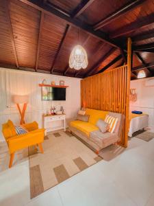 a living room with a couch and a tv at Shangri La Casas e Studios in Praia do Rosa