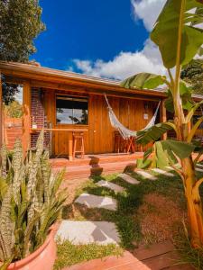 a house with a hammock in front of it at Shangri La Casas e Studios in Praia do Rosa