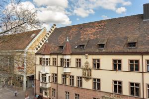 un gran edificio blanco con techo marrón en Deluxe Appartements am Münster, en Freiburg im Breisgau