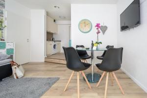 a dining room with a table and four chairs at Deluxe Appartements am Münster in Freiburg im Breisgau