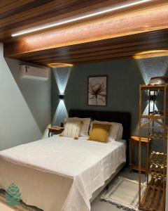 a bedroom with a large bed with a wooden ceiling at Chalés Amantes da Montanha - Visconde de Mauá in Bocaina de Minas