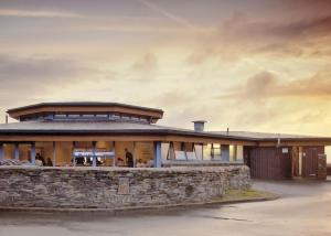 a large building with a stone wall at Sunbeach Holiday Park in Llwyngwril