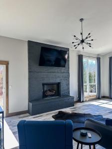 a living room with a fireplace and a blue couch at Brand New Yote Cabin, Pool Table, South of Norman in Purcell
