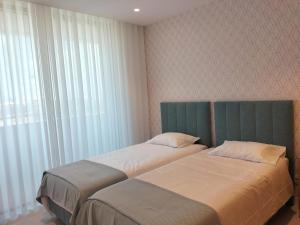 two beds sitting next to each other in a bedroom at Summer Days in Lagos +35 photos