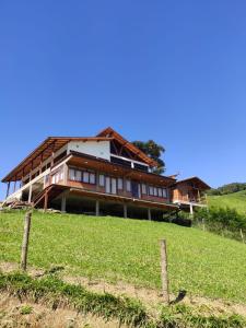 a house on top of a grassy hill at Chalés Amantes da Montanha - Visconde de Mauá in Bocaina de Minas