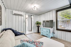 Una sala de estar con un sofá y un televisor. en Walk to Pier North Carolina Getaway in Oak Island, en Oak Island
