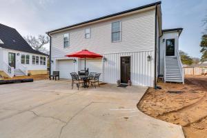 un patio con mesa y sombrilla junto a un edificio en Walk to Pier North Carolina Getaway in Oak Island, en Oak Island