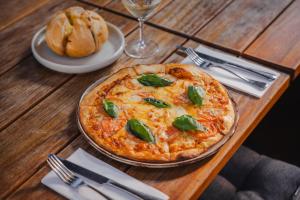 a pizza sitting on top of a wooden table at Shoreline Hotel in Hobart +55 photos