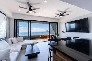 un salon avec un canapé et une télévision à écran plat dans l'établissement Departamento con vista al mar1502-Torre Catania, à Mazatlán