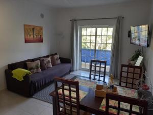 ein Wohnzimmer mit Sofa und Tisch in der Unterkunft Flamingos Apartment with 2 swimming pool com check in e check out ao domingo em julho e agosto in Albufeira + 19 Fotos