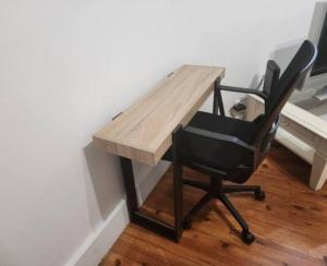 a desk with a black chair next to a wall at Beau 2-pieces rch très proche de Paris in Gentilly