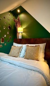 a bedroom with a green wall with a bed at Élégant appartement lumineux hypercentre Orléans in Orléans