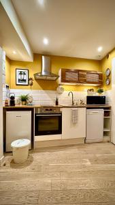 a kitchen with yellow walls and white appliances at Élégant appartement lumineux hypercentre Orléans in Orléans +30 photos
