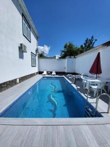 a small swimming pool with a table and an umbrella at Gabala Deluxe 4-bedrooms Villa in Gabala