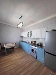 a kitchen with blue cabinets and a table in it at Gabala Deluxe 4-bedrooms Villa in Gabala