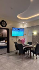 une salle à manger avec une table et une télévision au mur dans l'établissement شاليهات بالي, à Jilhayah 43 autres photos