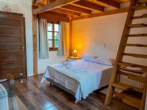 a bedroom with a bed in a wooden room at Chalés dos Pássaros in Gramado